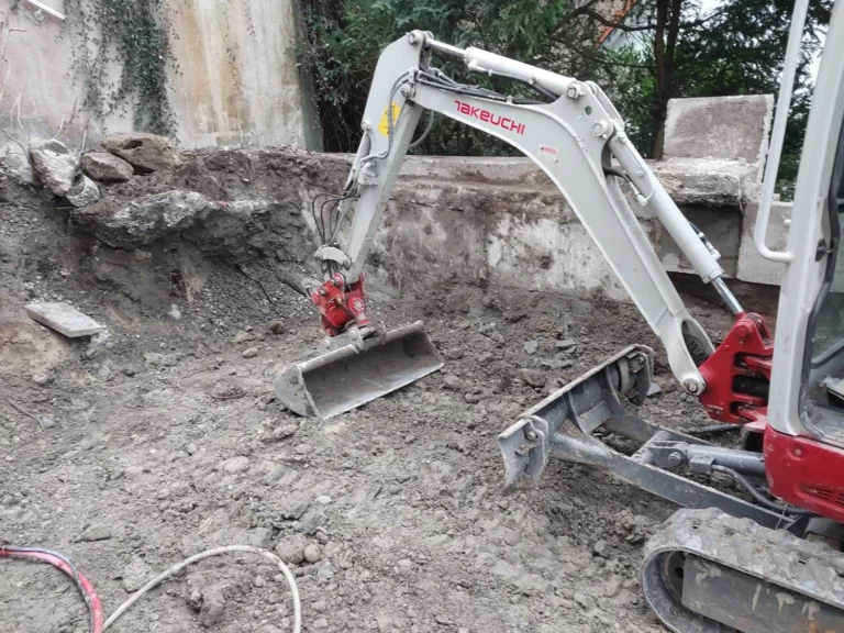 Ein kleiner Bagger, der auf einer Baustelle Erdarbeiten durchführt.