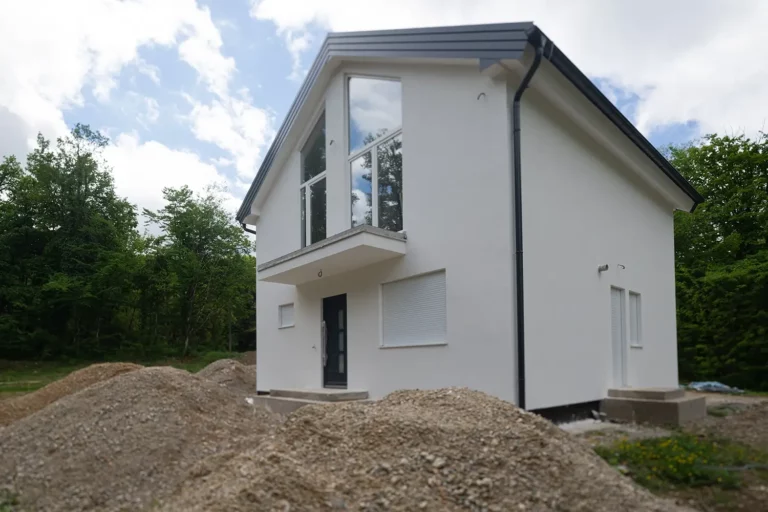 Weißes, modernes Haus mit großen Fenstern, ideal für Renovierungen und Modernisierungen.